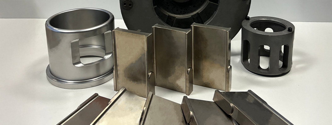 Metallkomponenten in verschiedenen Formen und Größen, in Silber- und Grautönen auf einem Tisch.